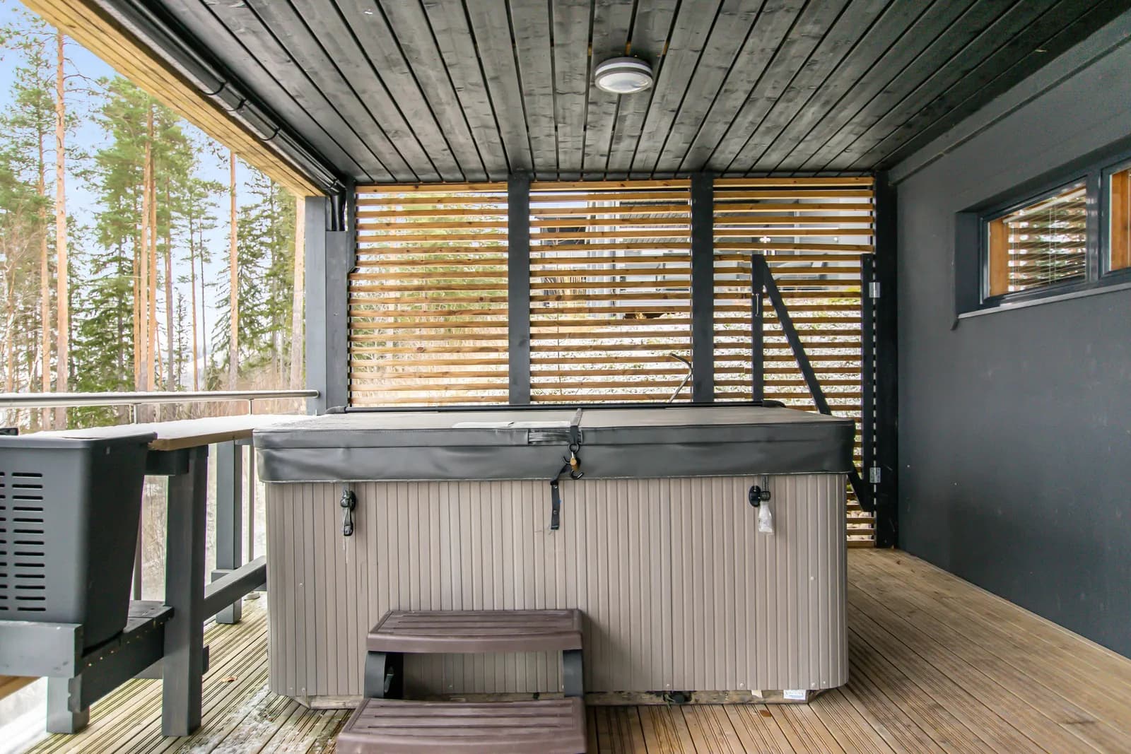 Outdoor hot tub on the covered terrace at Salavan Tsaari